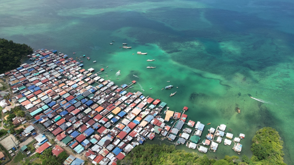 Aerial view of a village on Gaya Island, Kota Kinabalu, Sabah Malaysia, situated on the coast reaching into the sea and very susceptible to rising sea levels